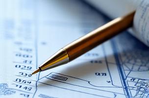 Conceptual image of financial planning notebook and pen on a blueprint