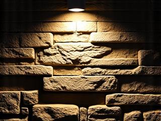 Graze lighting highlighting the rough texture of a stone retaining wall
